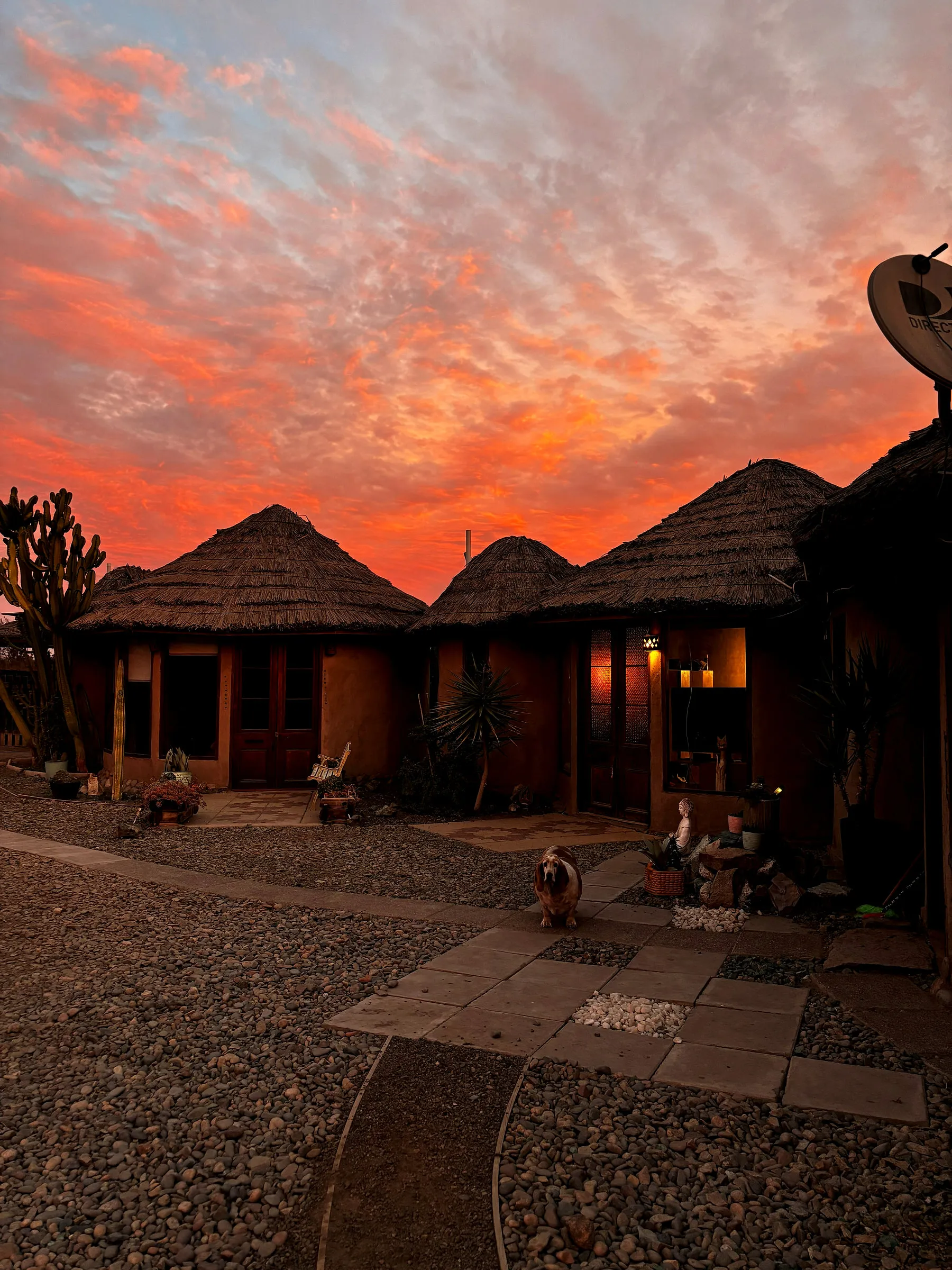 Cabañas de adobe con techo de totora al atardecer en Relajo Desierto