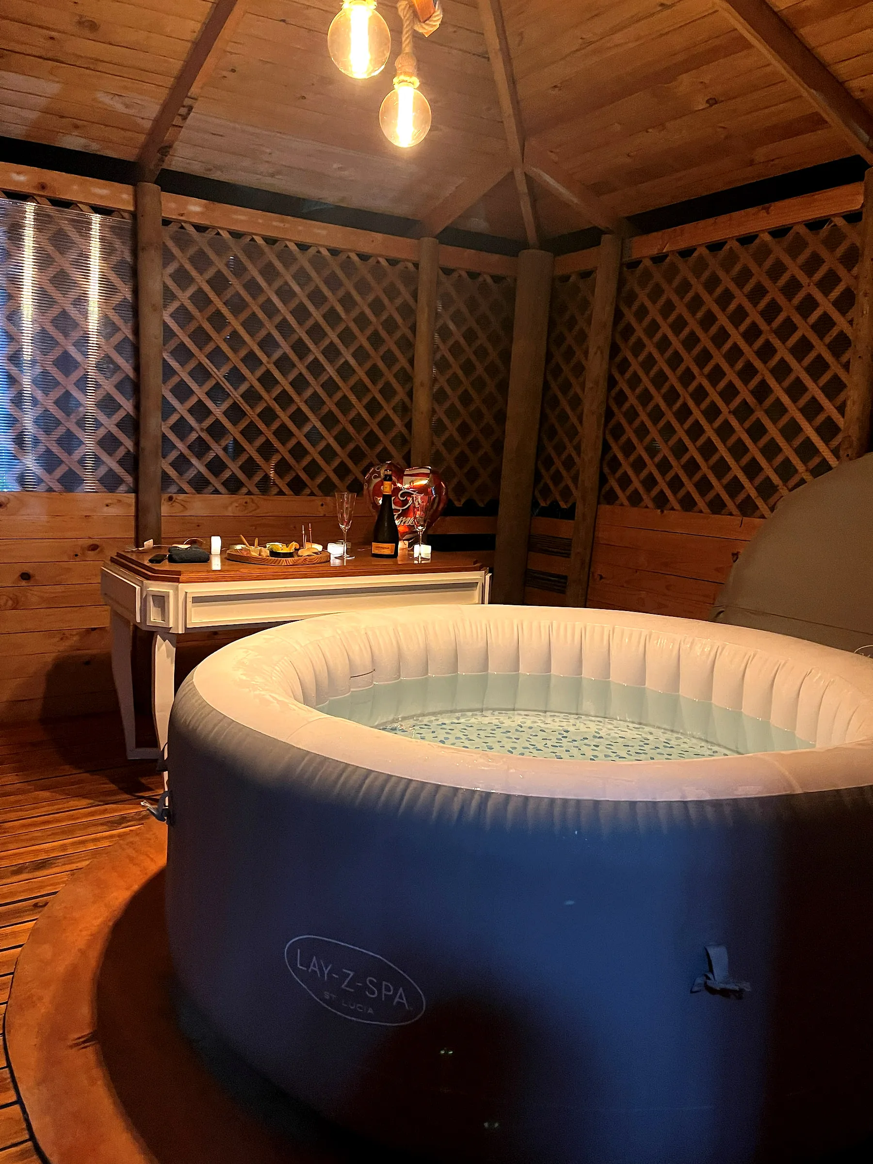Jacuzzi con hidroburbujas y la mesa servida con tabla de picoteo y vino