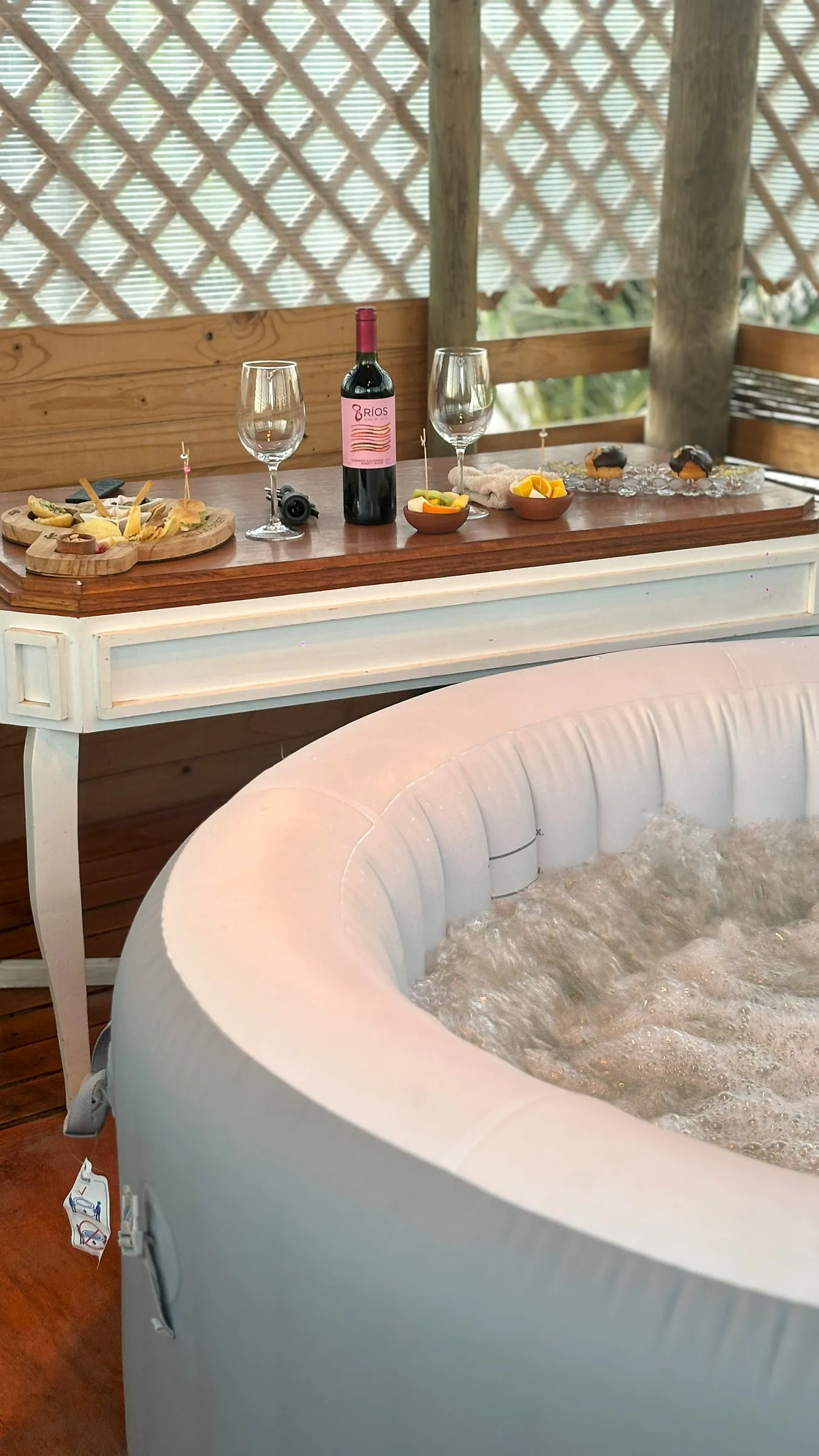 Jacuzzi con hidroburbujas y la mesa servida con tabla y bebestible